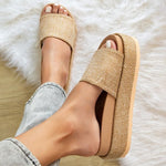 Woman wearing woven raffia flatform slide sandals in neutral beige, showcasing chunky espadrille-style platform perfect for summer casual outfits.