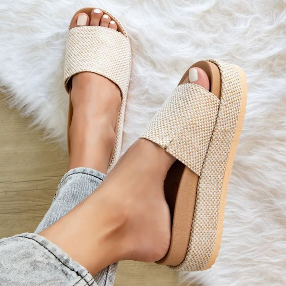 Woman wearing woven raffia flatform slide sandals in light beige, showcasing chunky espadrille-style platform perfect for summer casual outfits.