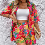 Women's tropical floral two-piece set with relaxed short-sleeve button shirt and high-waist shorts in vibrant fuchsia, coral, lime, and turquoise hibiscus print – lightweight resort outfit.