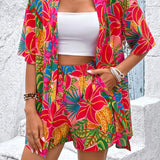 Women's tropical floral two-piece set with relaxed short-sleeve button shirt and high-waist shorts in vibrant fuchsia, coral, lime, and turquoise hibiscus print – lightweight resort outfit.