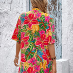 Women's tropical floral two-piece set with relaxed short-sleeve button shirt and high-waist shorts in vibrant fuchsia, coral, lime, and turquoise hibiscus print – lightweight resort outfit.