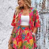 Women's tropical floral two-piece set with relaxed short-sleeve button shirt and high-waist shorts in vibrant fuchsia, coral, lime, and turquoise hibiscus print – lightweight resort outfit.
