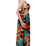 Woman wearing a vibrant tropical floral cut-out halter maxi dress with gold chain belt and thigh-high slit.