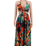 Woman wearing a vibrant tropical floral cut-out halter maxi dress with gold chain belt and thigh-high slit.