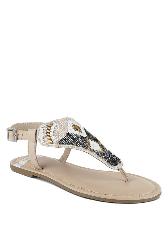 Pink, black and beige flat sandals with Aztec-style hand-beaded T-strap uppers, adjustable ankle buckle and cushioned footbed, boho summer women’s footwear.