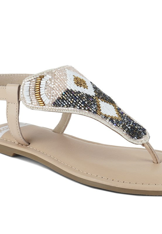 Pink, black and beige flat sandals with Aztec-style hand-beaded T-strap uppers, adjustable ankle buckle and cushioned footbed, boho summer women’s footwear.