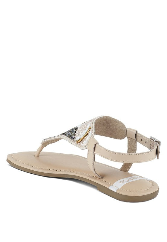 Pink, black and beige flat sandals with Aztec-style hand-beaded T-strap uppers, adjustable ankle buckle and cushioned footbed, boho summer women’s footwear.