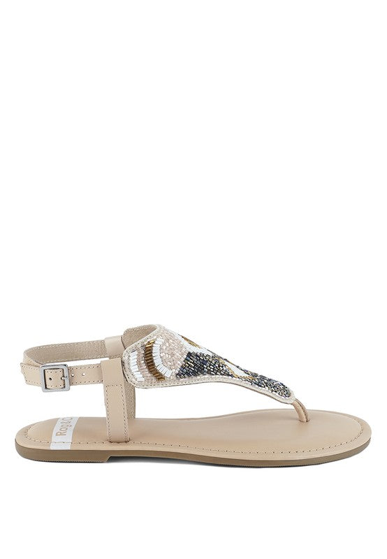 Pink, black and beige flat sandals with Aztec-style hand-beaded T-strap uppers, adjustable ankle buckle and cushioned footbed, boho summer women’s footwear.