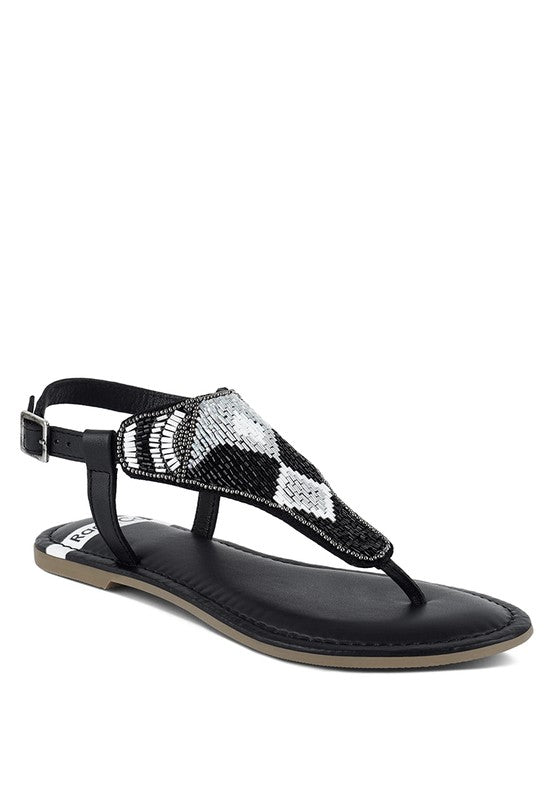 Pink, black and beige flat sandals with Aztec-style hand-beaded T-strap uppers, adjustable ankle buckle and cushioned footbed, boho summer women’s footwear.