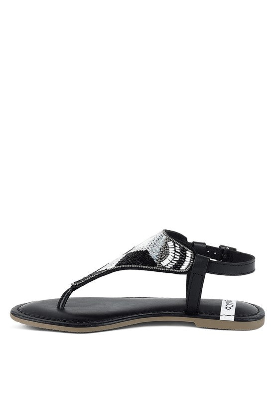 Pink, black and beige flat sandals with Aztec-style hand-beaded T-strap uppers, adjustable ankle buckle and cushioned footbed, boho summer women’s footwear.