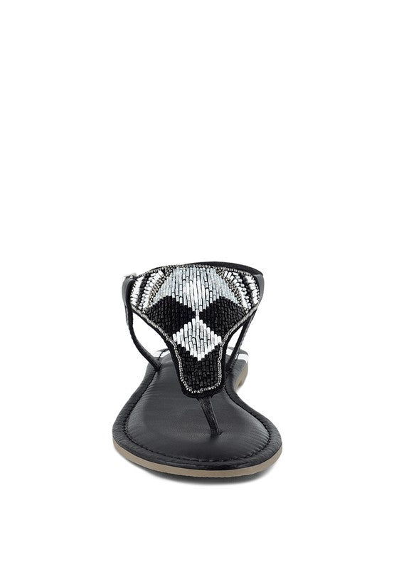 Pink, black and beige flat sandals with Aztec-style hand-beaded T-strap uppers, adjustable ankle buckle and cushioned footbed, boho summer women’s footwear.