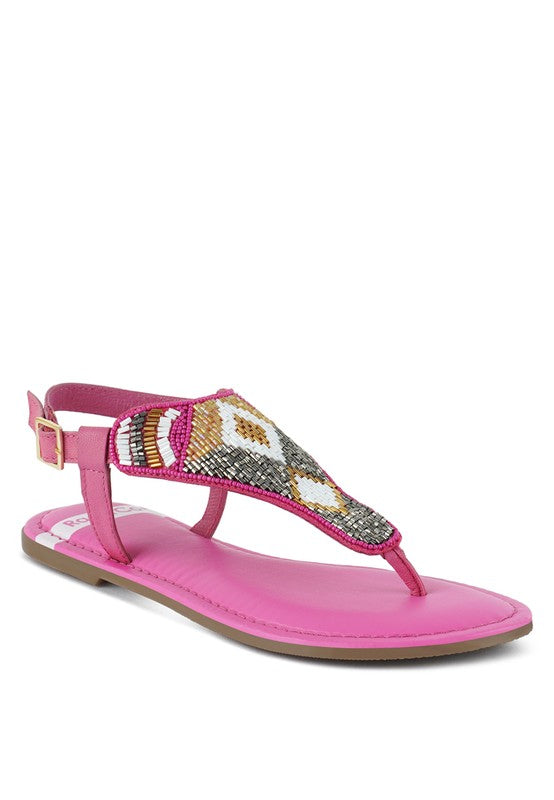 Pink, black and beige flat sandals with Aztec-style hand-beaded T-strap uppers, adjustable ankle buckle and cushioned footbed, boho summer women’s footwear.