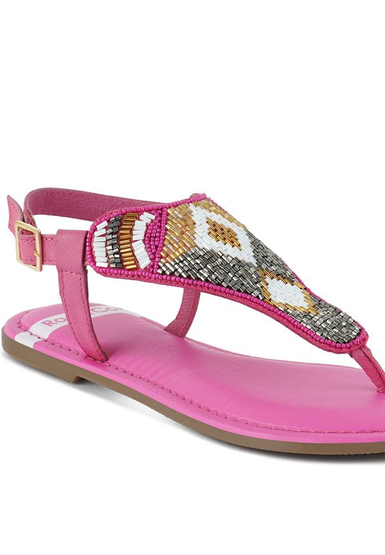 Pink, black and beige flat sandals with Aztec-style hand-beaded T-strap uppers, adjustable ankle buckle and cushioned footbed, boho summer women’s footwear.