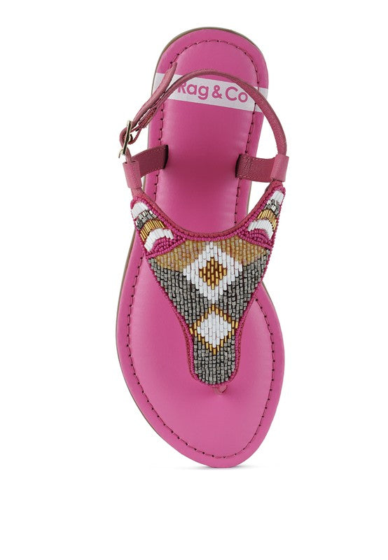 Pink, black and beige flat sandals with Aztec-style hand-beaded T-strap uppers, adjustable ankle buckle and cushioned footbed, boho summer women’s footwear.