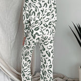 Back view of woman wearing sage green and white leopard print two-piece lounge set with long sleeves and wide-leg pants.