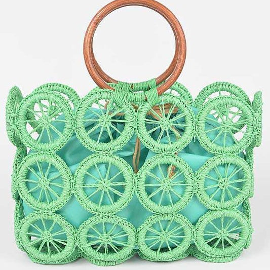 Mint green raffia circle-grid tote with wooden round handles and teal drawstring insert.