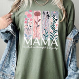 Green T-shirt with pastel pink and teal floral panel design and bold ‘MAMA’ graphic reading ‘Clothed in Strength & Dignity.