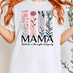 White T-shirt with pastel pink and teal floral panel design and bold ‘MAMA’ graphic reading ‘Clothed in Strength & Dignity.