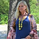 Double strand blue lapis lazuli bead necklace with natural gold and gray flecks, displayed on a light wooden surface.