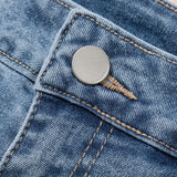 Women's high-waisted denim shorts with faux pearl embellishments and frayed hem – trendy summer jean shorts for casual and chic outfits. Showing the detail.