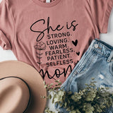 Dusty-rose graphic T-shirt reading ‘She is strong, loving, warm, fearless, patient, selfless—mom’ styled flat-lay with tan fedora, denim shorts, and greenery.
