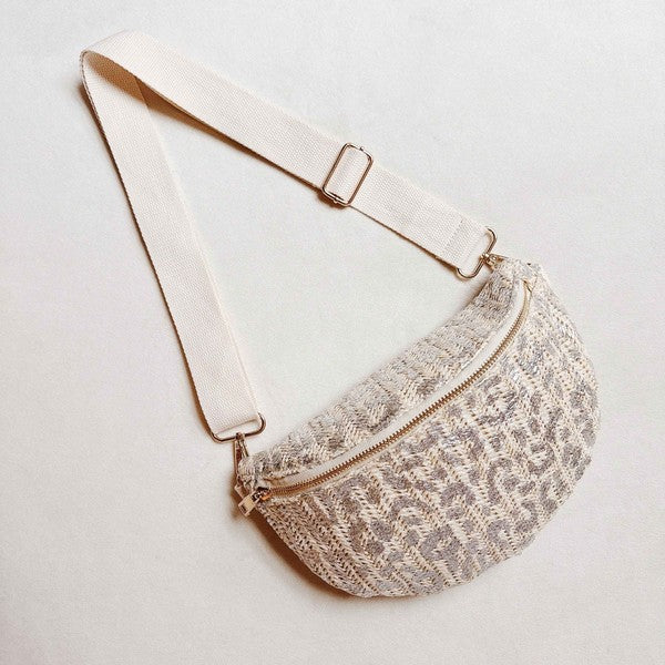 Silver and ivory woven leopard-print crossbody belt bag with ivory strap and zipper, displayed on a neutral background.
