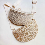 Gold or Silver and ivory woven leopard-print crossbody belt bag with adjustable ivory strap and zip closure, laid flat on a white background.